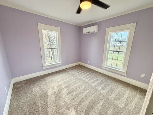 Carpeting in bedroom with purple walls 